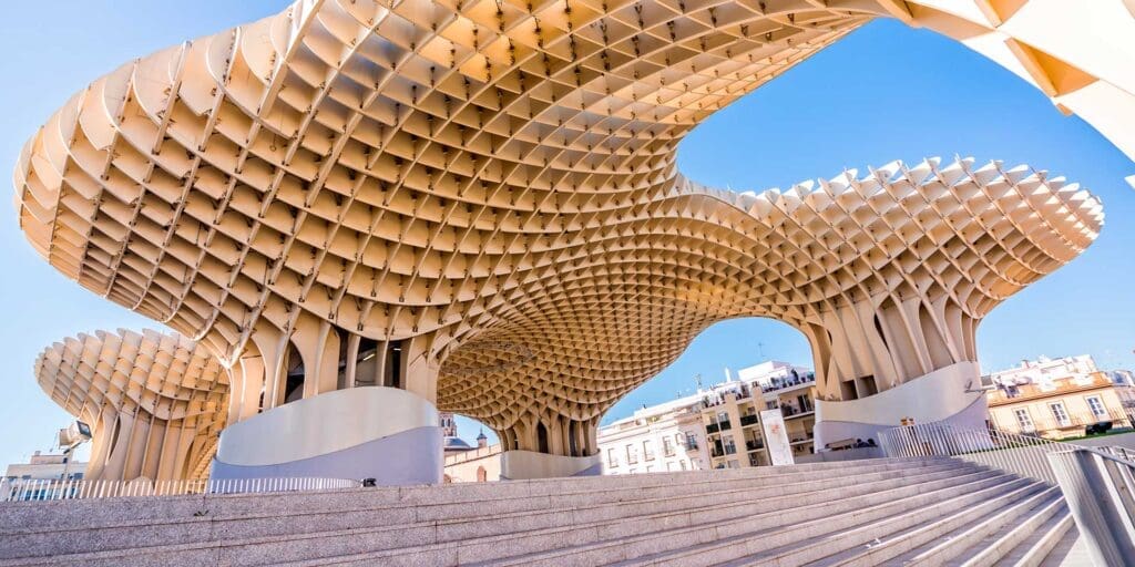 Metropol Parasol, commonly known as 'Las Setas', a modern wooden structure with a honeycomb design, towering over the Plaza de la Encarnación in Sevilla, offering a blend of contemporary architecture amidst the city's historic landscape.
