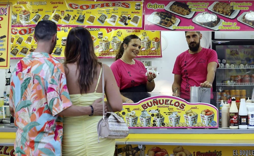 Yellow food carts selling Buñuelos at the Feria de Málaga